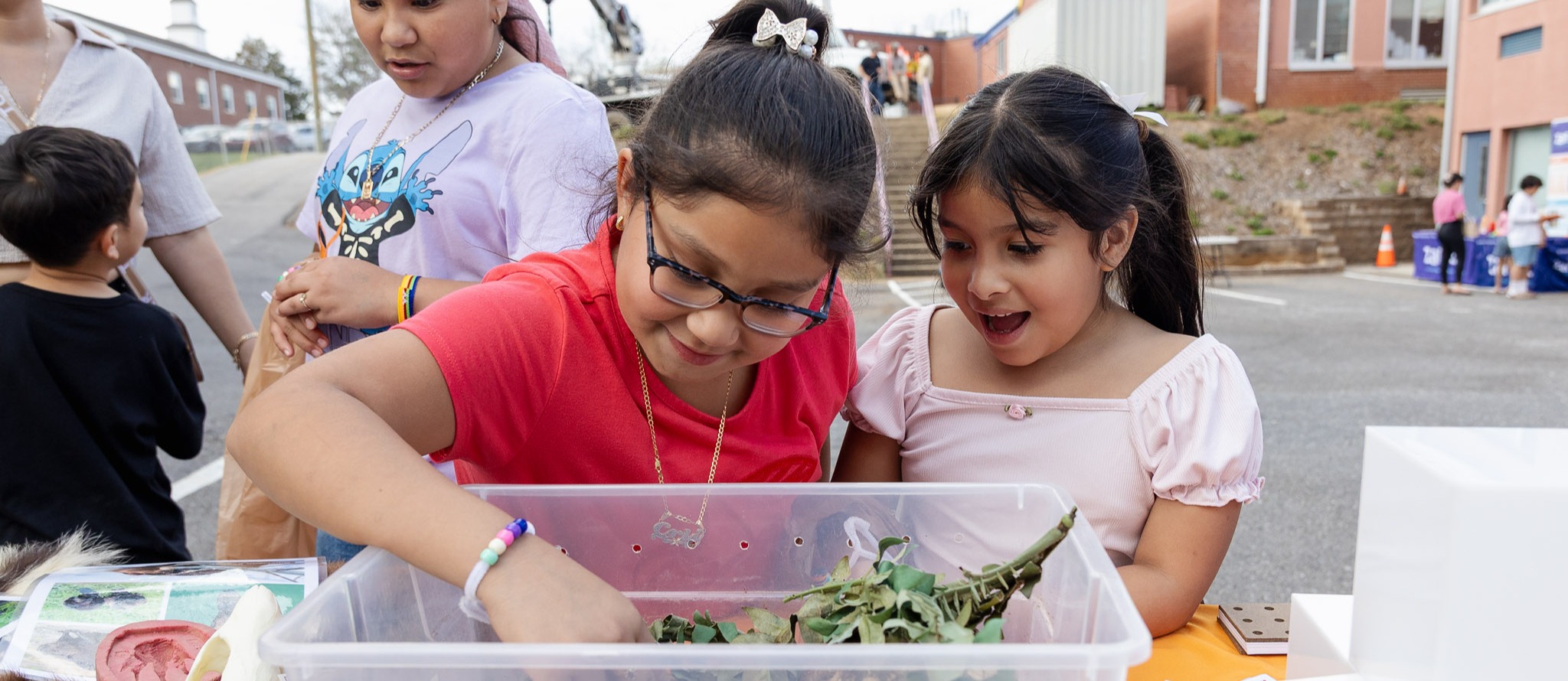 Two girls look into a turtle enclosure.