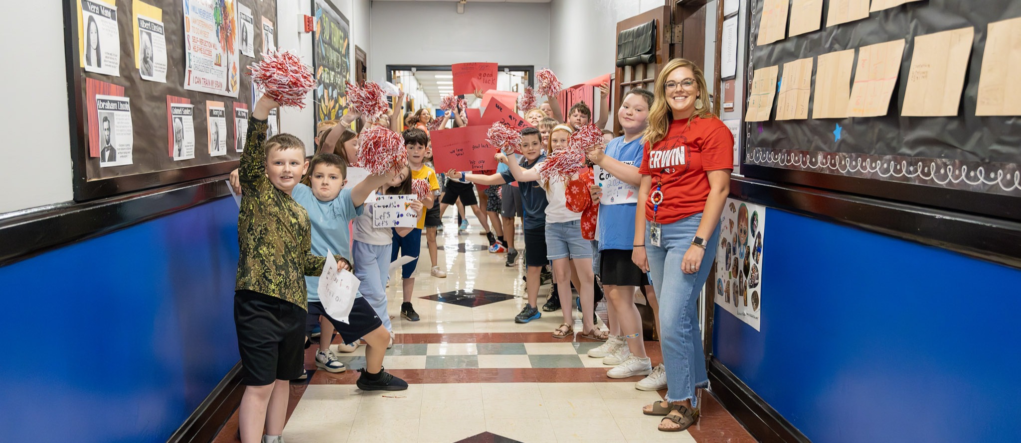 Students wave pom poms and cheer during the Erwin High School Senior Walk.