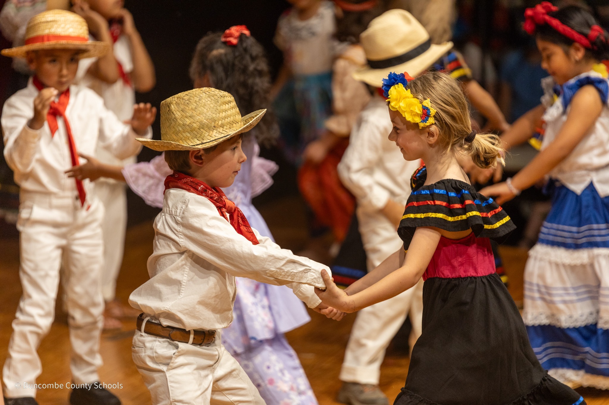 Two Dual Language students dancing on stage, dressed in South American attire.