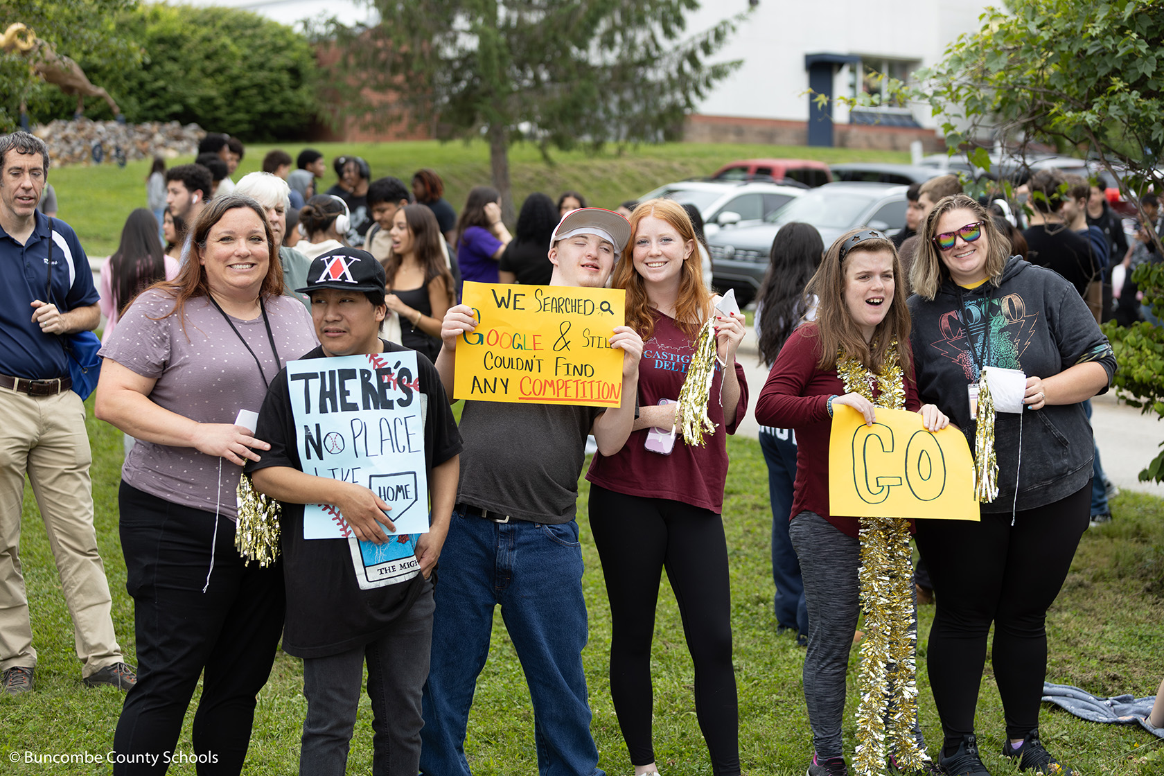 Group of students and staff holding signs for the TC Baseball team as they left for the state championship game. 