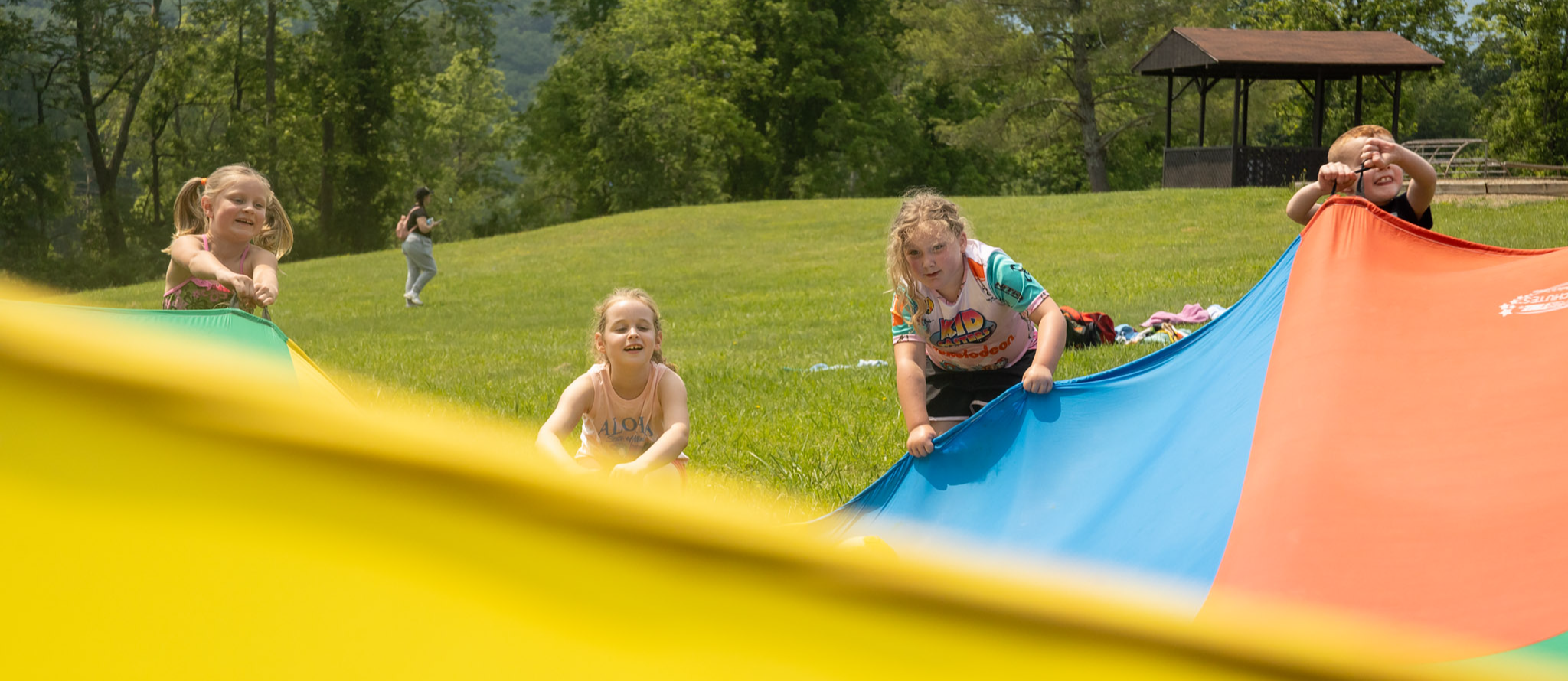 Students play with a colorful parachute during Field Day 2025