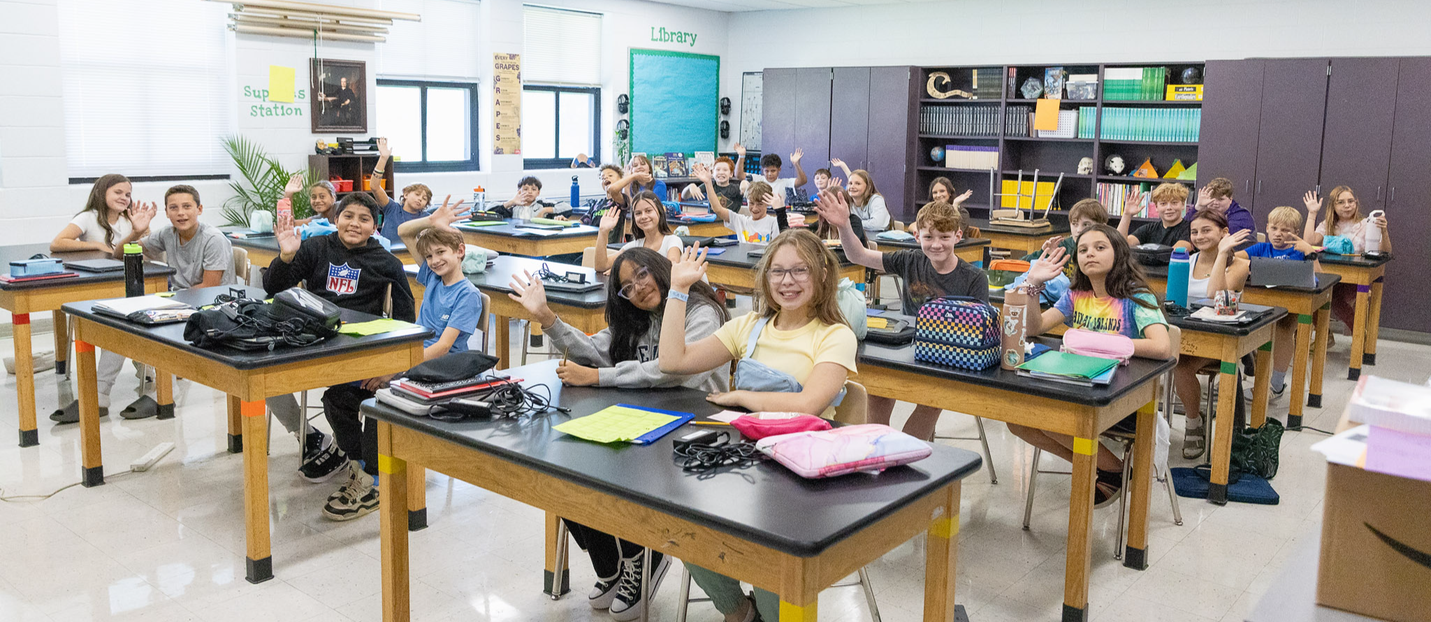 A classroom full of students waving.