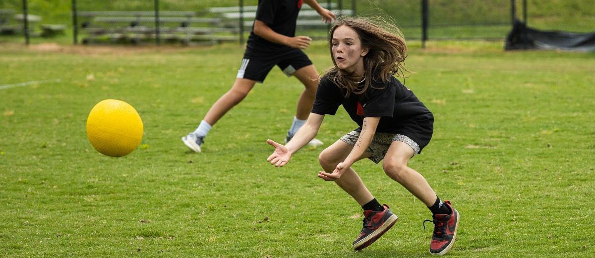 A student gets ready to catch a kickball.