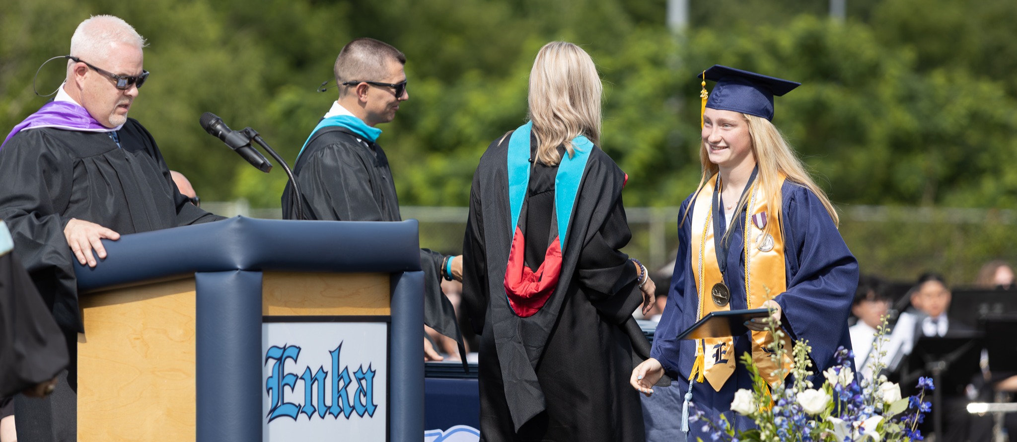 Female student walking across the stage at Enka HS 2025 graduation 
