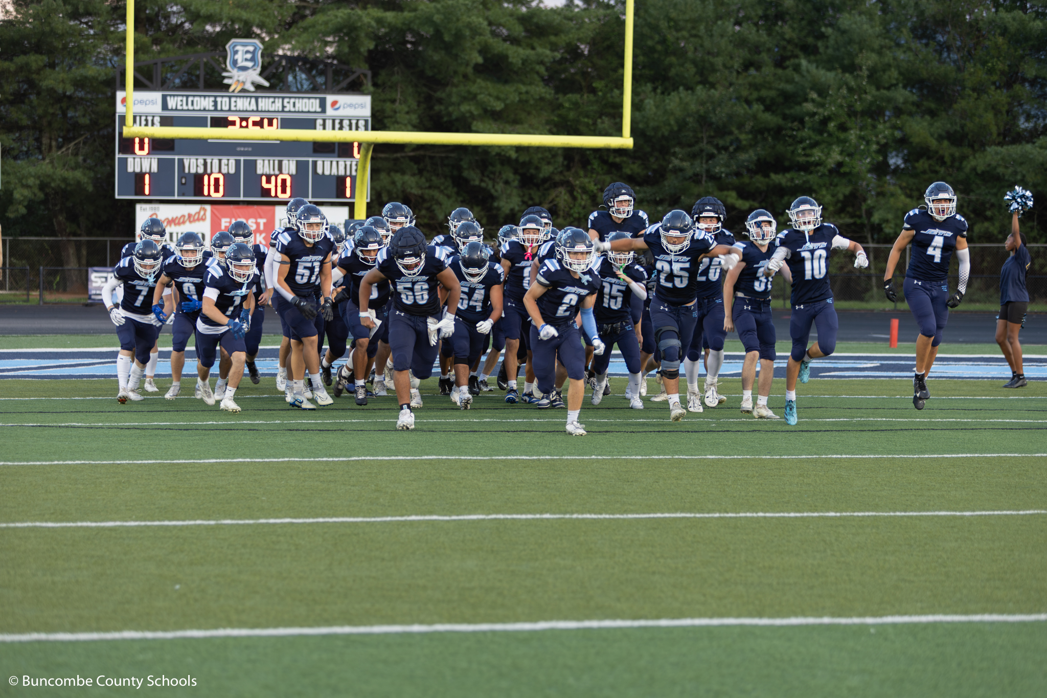 Football team running on to the field at the start of home game. 