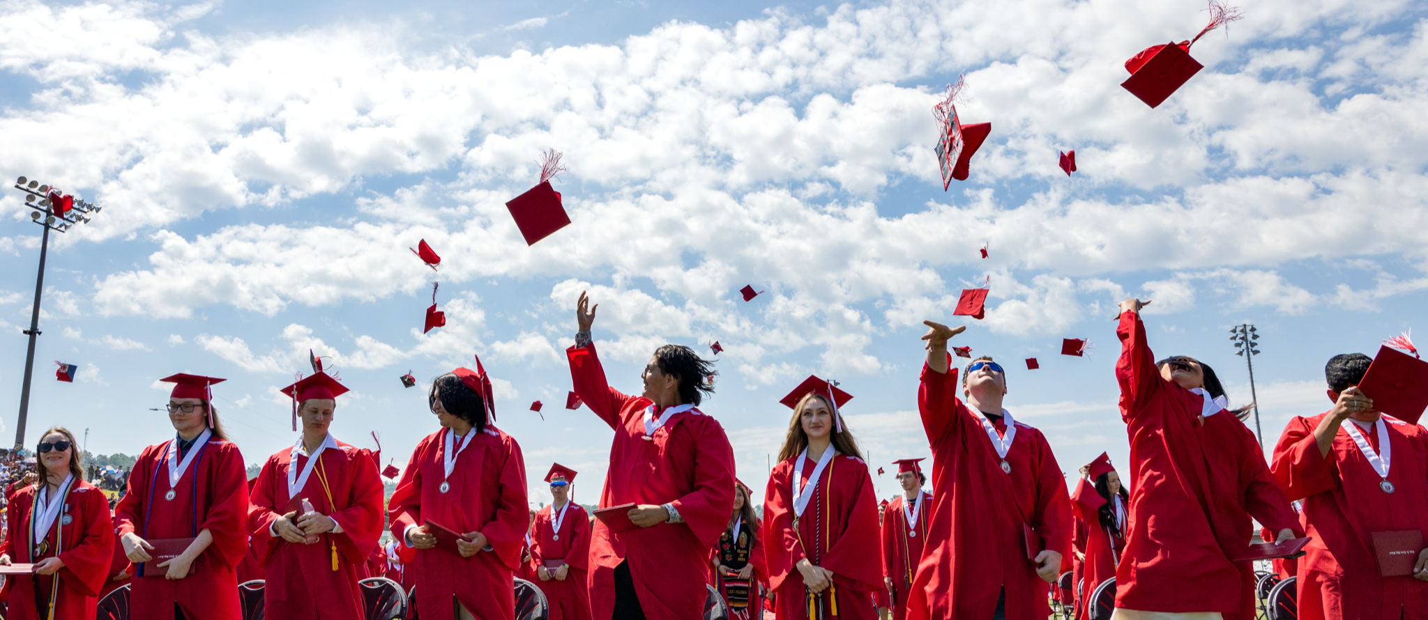 Graduates throw their hats in the air.