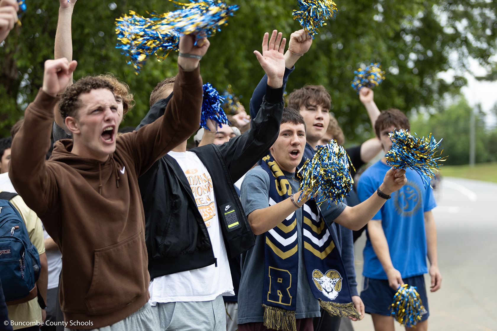 Group of male students cheering on the baseball team. 