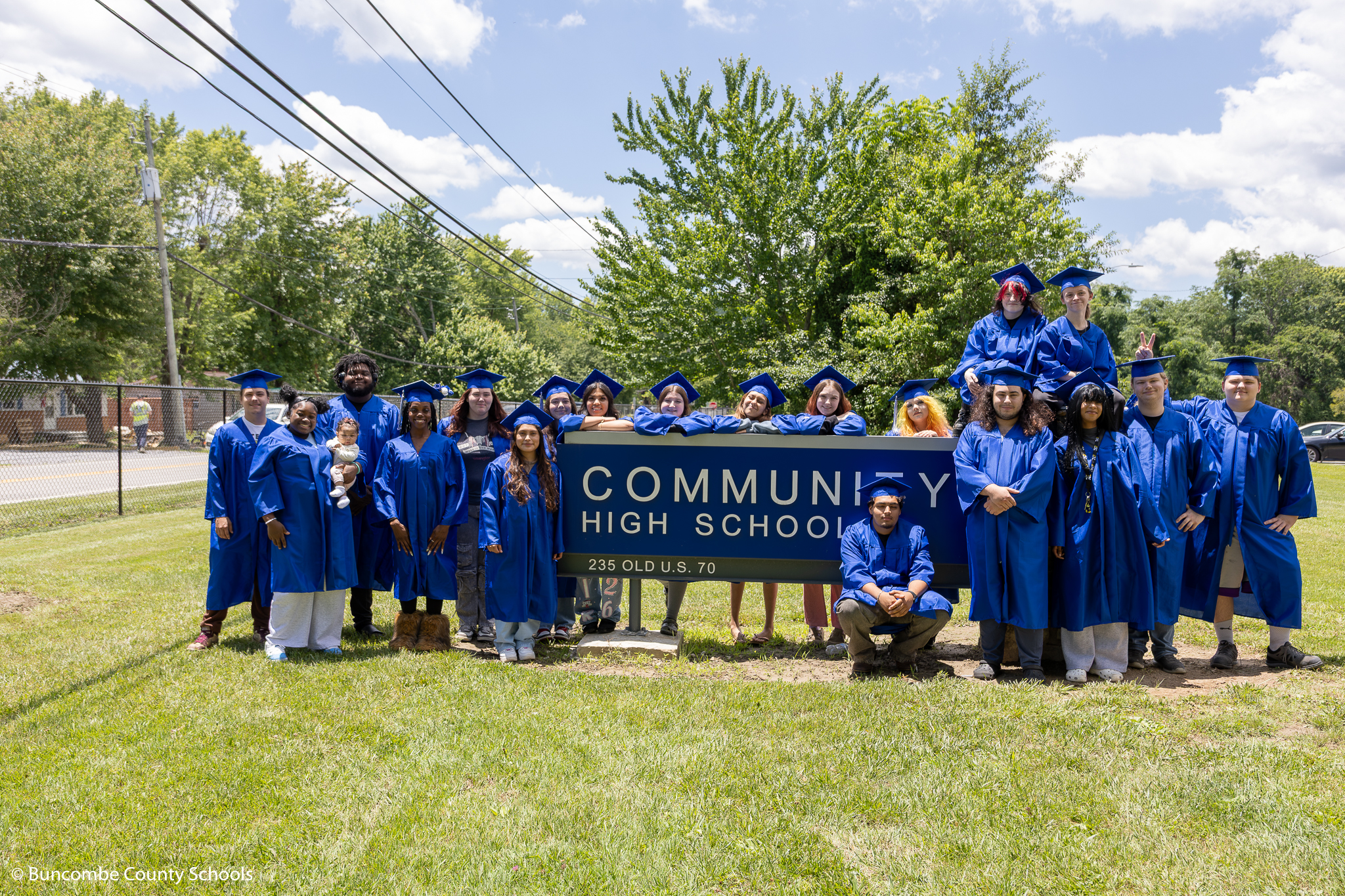 The Class of 2026 in cap and gown outside the school. 