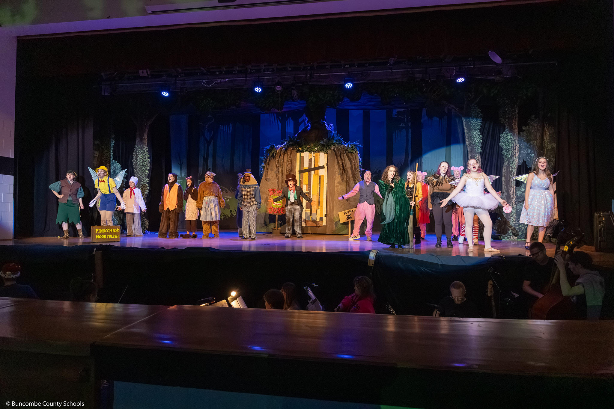 Students dressed fairy tale creatures perform on stage during the 2026 "Shrek The Musical" dress rehearsal.