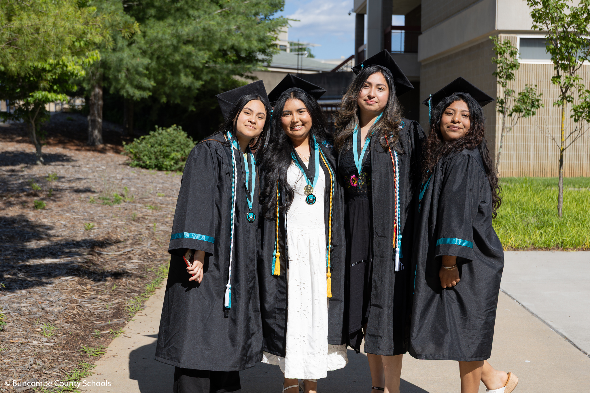 Group of four senior girls posing outside for a photo. 