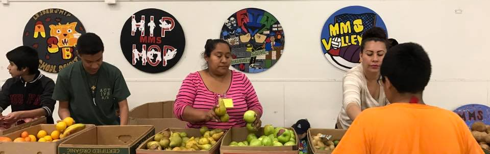 People behind fruit boxes