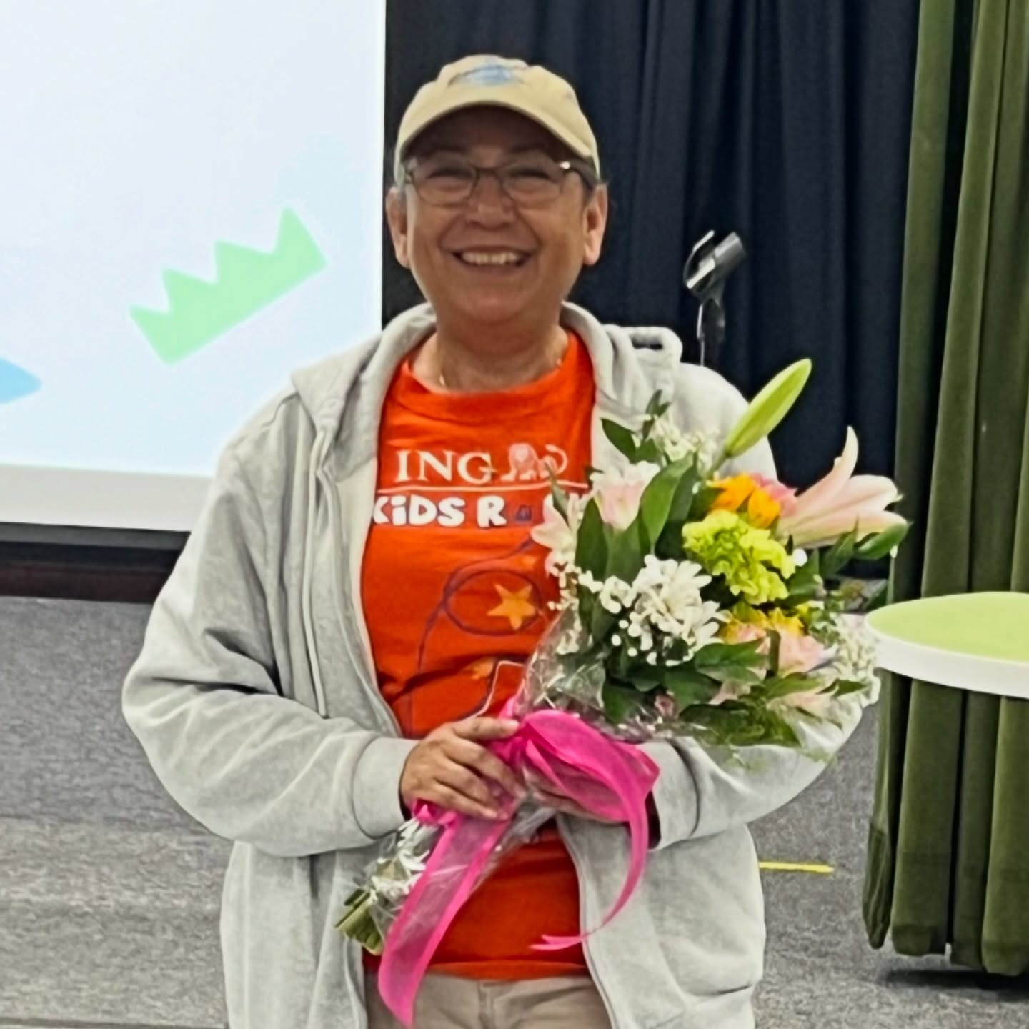 Classified Employee of the Year: Mrs. Mayra holding a bouquet of flowers