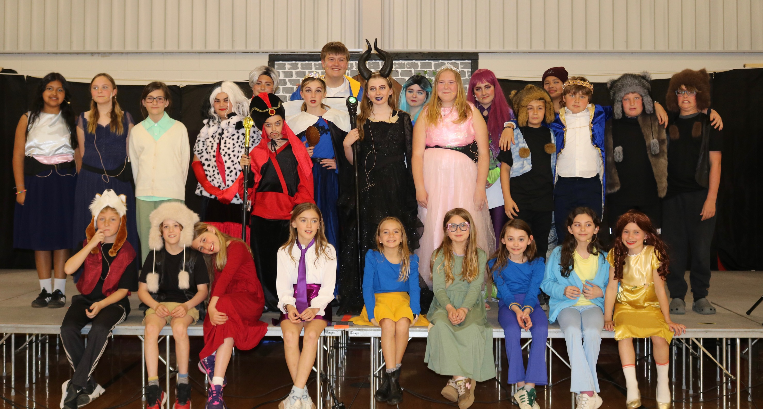 Students on a stage in costume after a drama club performance