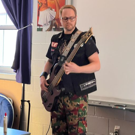 Teacher dressed as a rockstar with guitar
