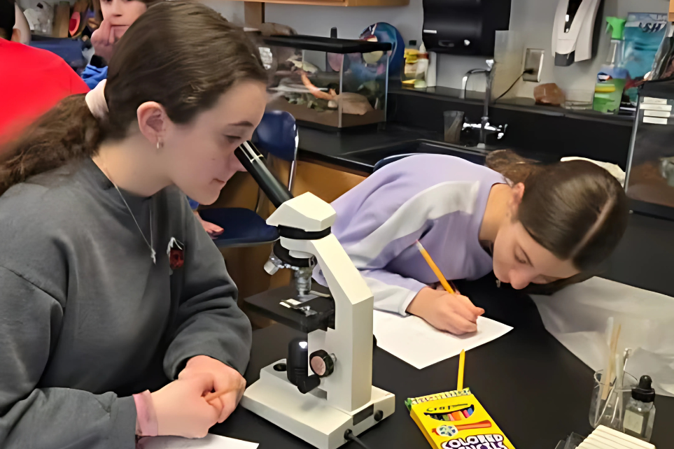 students looking through a microscope in science class