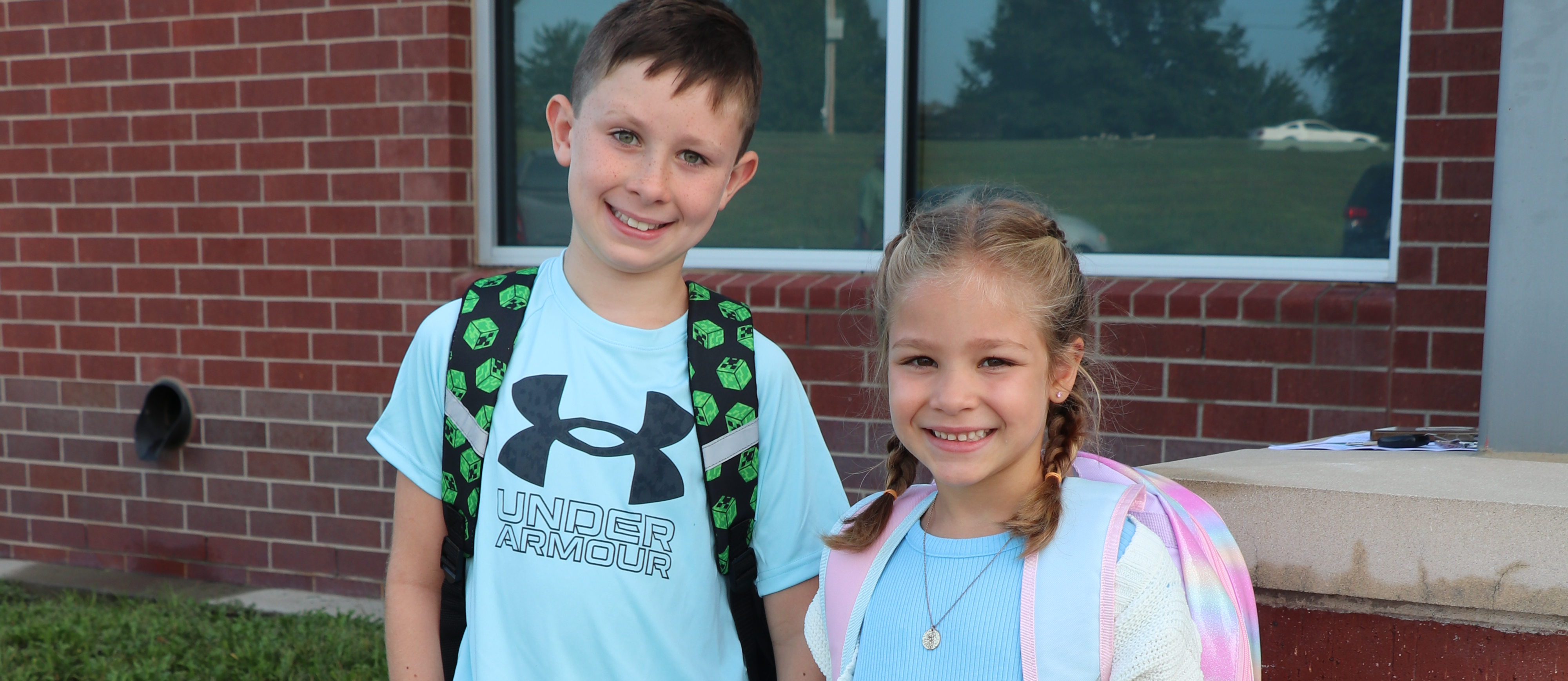 Kids smile at the camera on the first day of school