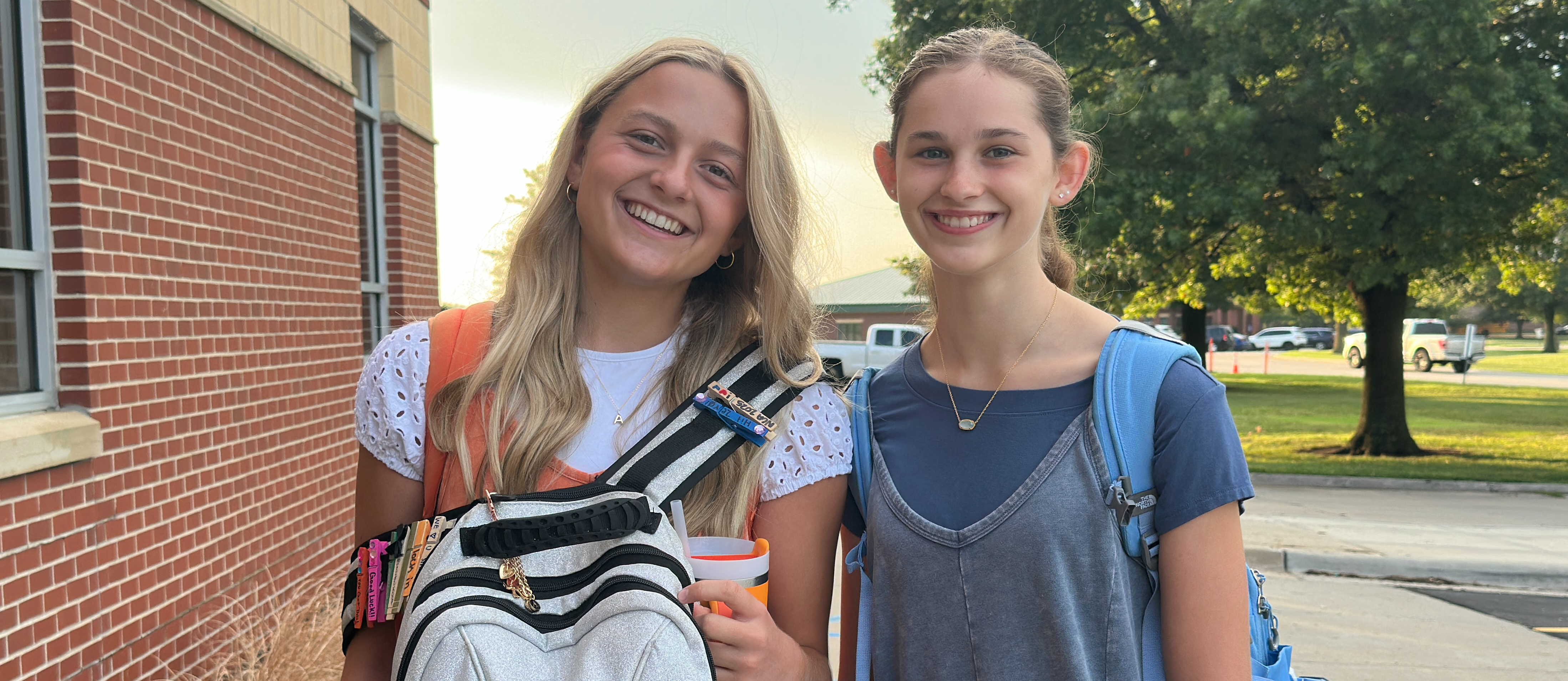 two girls posing in front of the high school