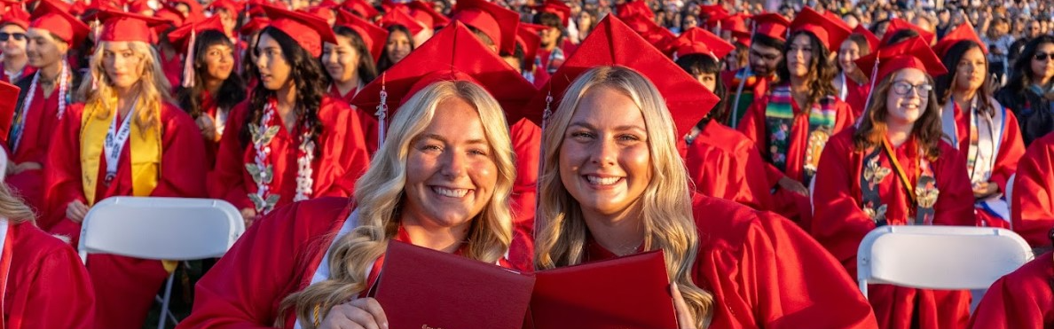 two students in red cap and gown