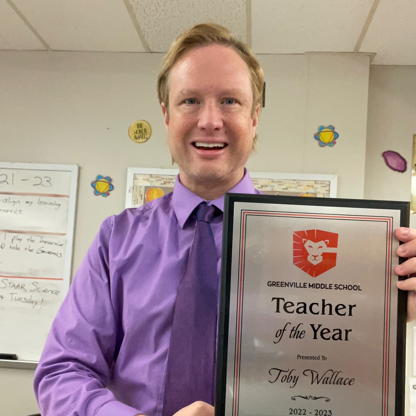 Toby Wallace smiling holding an award of teacher of the year