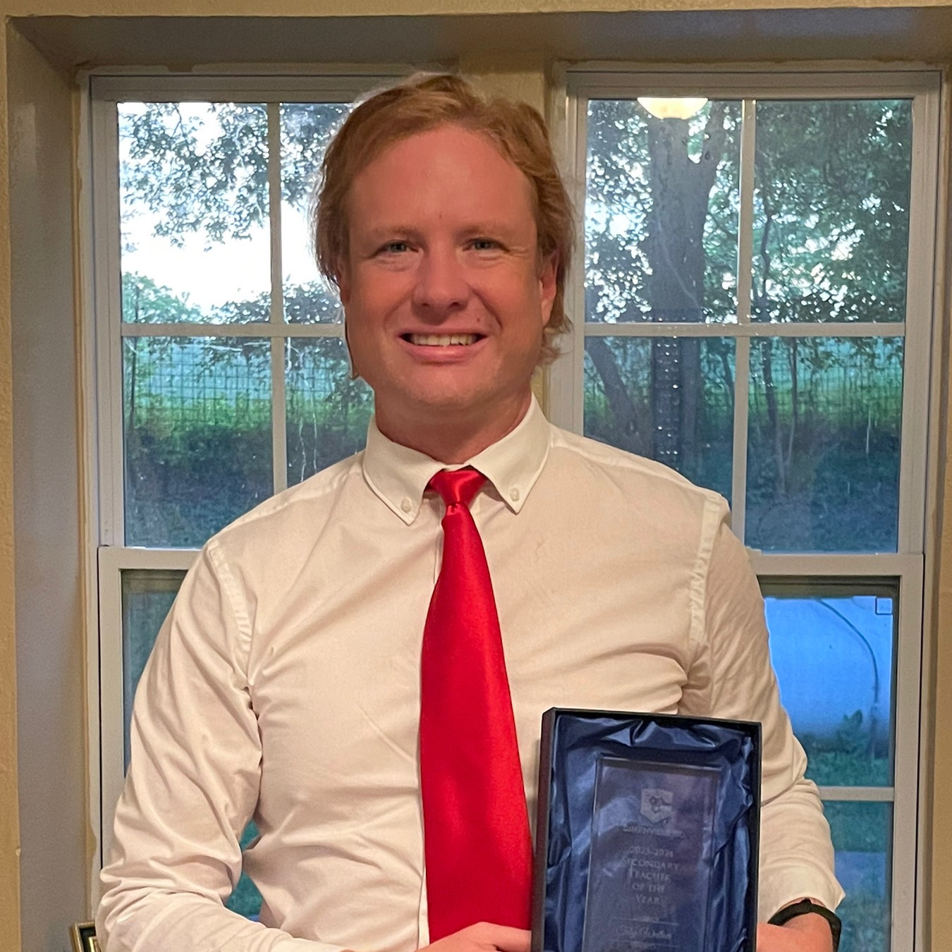 Toby Wallace smiling holding an award of teacher of the year