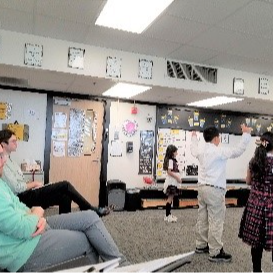 students rehearsing a dance in a classroom