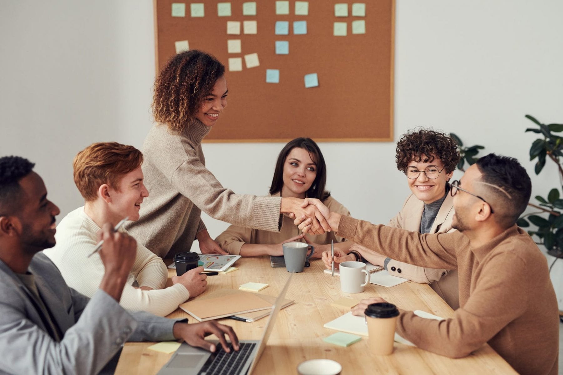 A group of professionals greeting each other in a professional setting.