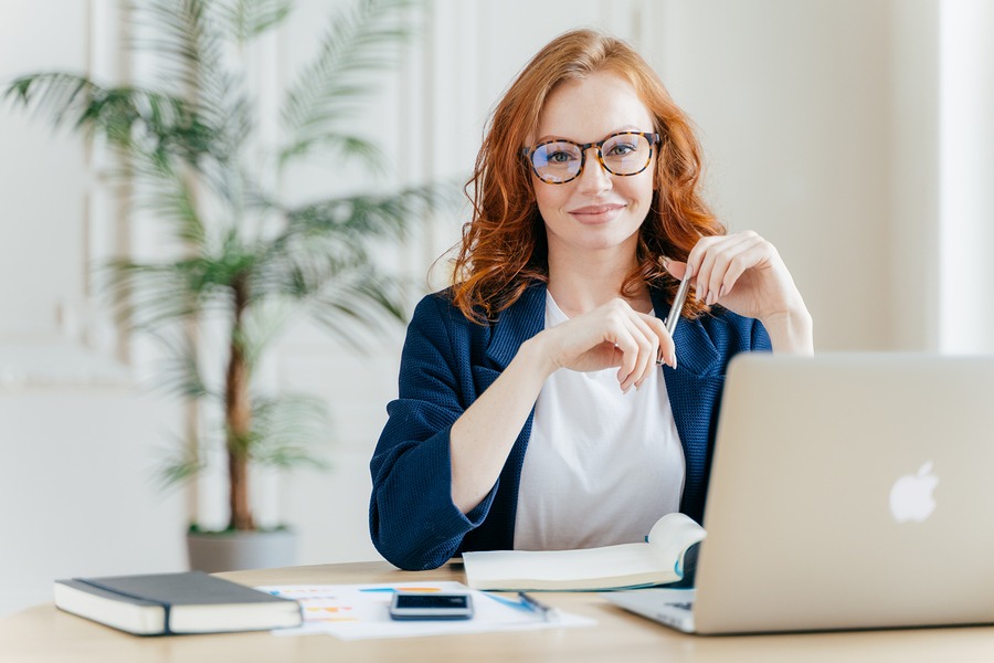 woman smiling and working on a laptop