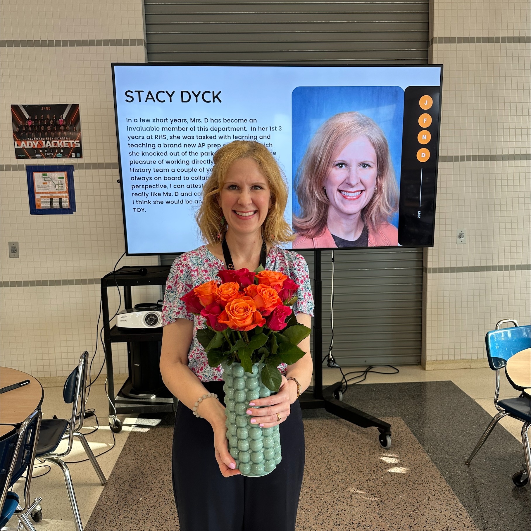 Stacy Dyck smiling holding flowers for being awarded teacher of the year