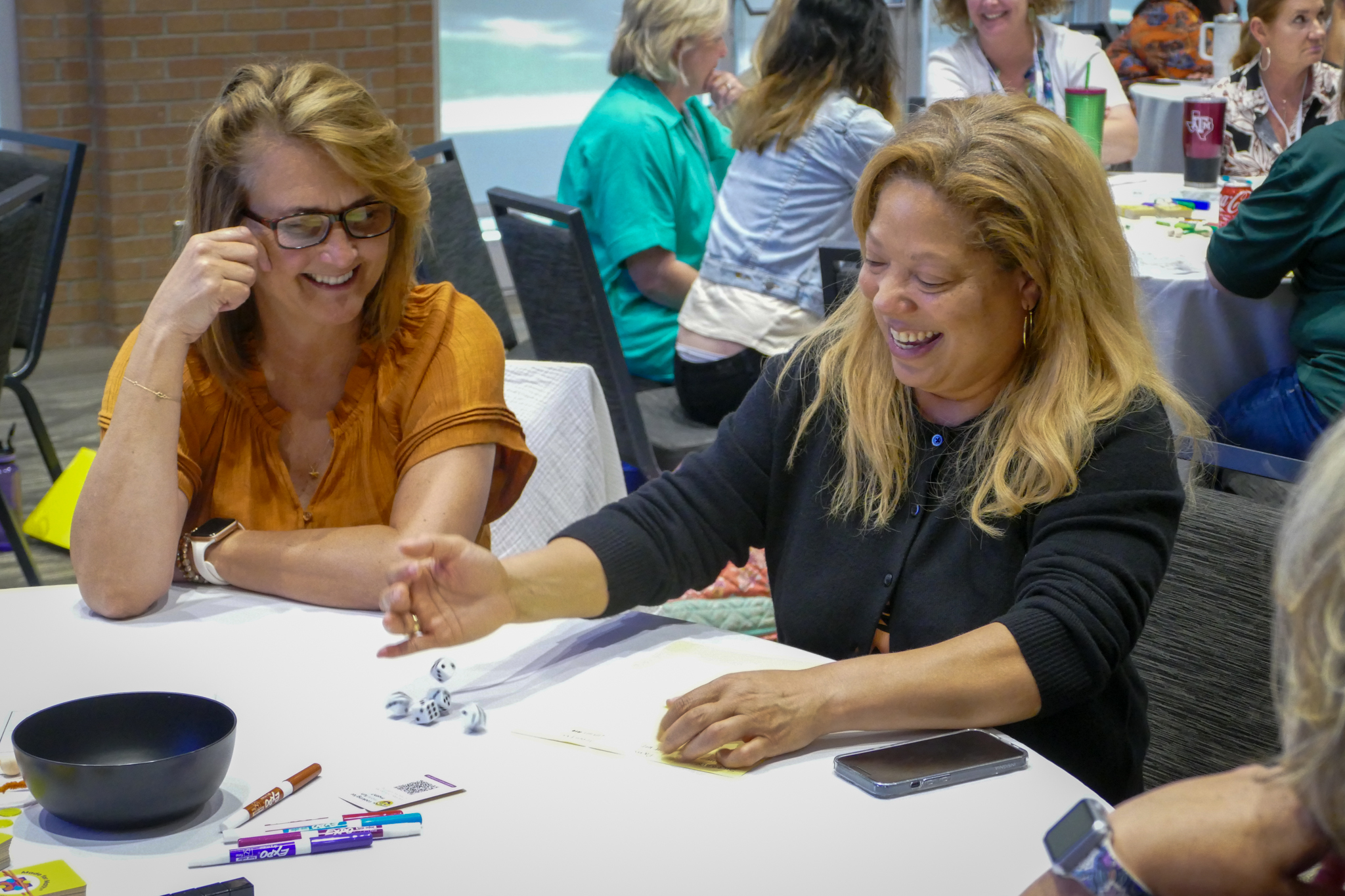 Two people smiling while rolling a dice