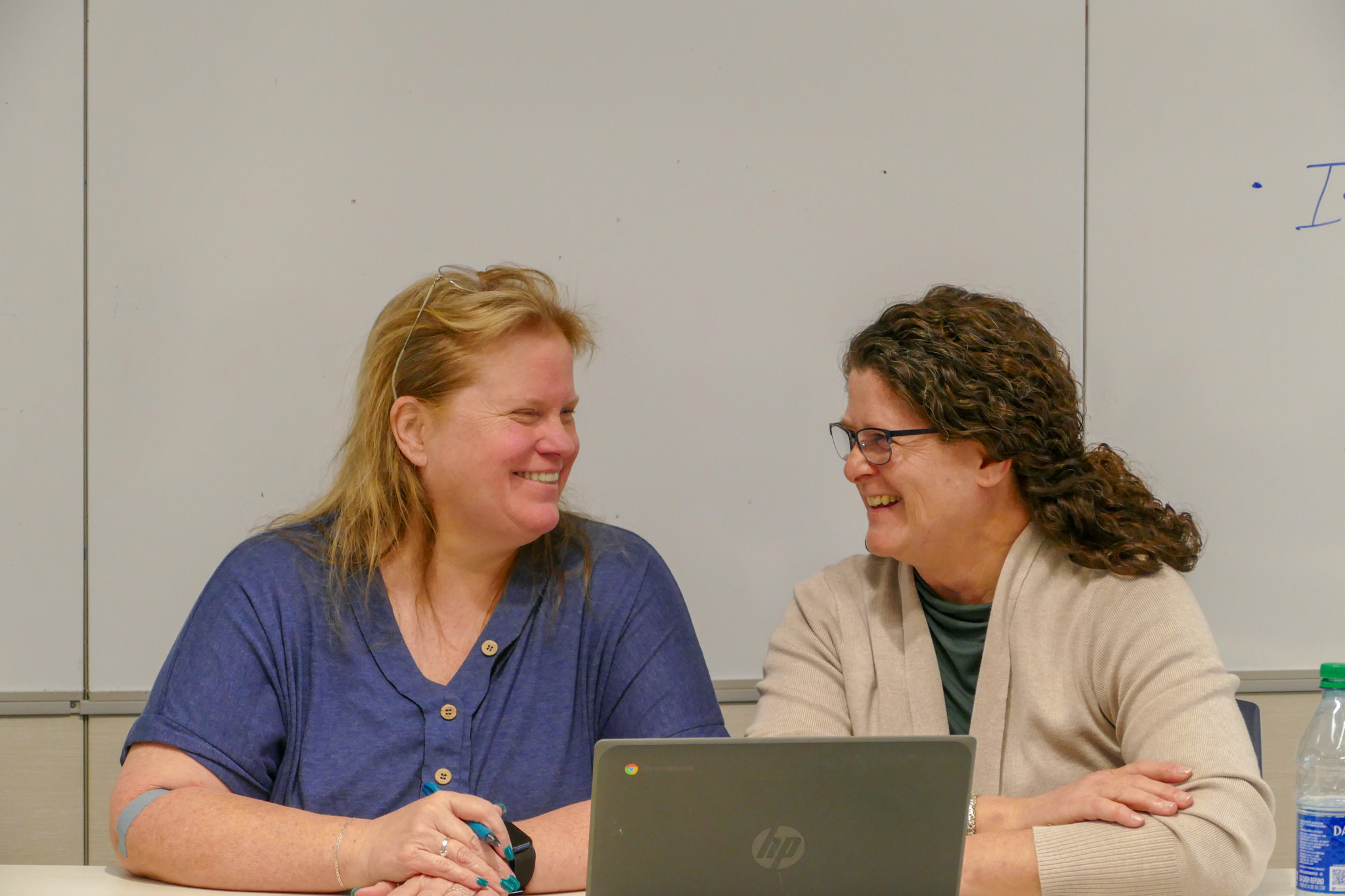 Two ladies laughing and talking during a conference