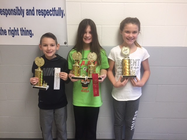 3 students holding trophies