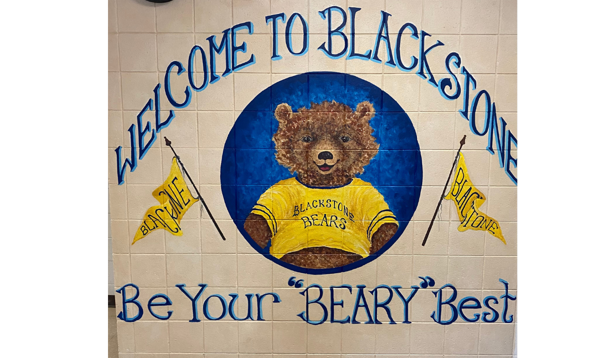 Welcome to Blackstone, Be your "Beary" Best; mural of Blackstone Bear in a yellow shirt and yellow triangular flags on each side
