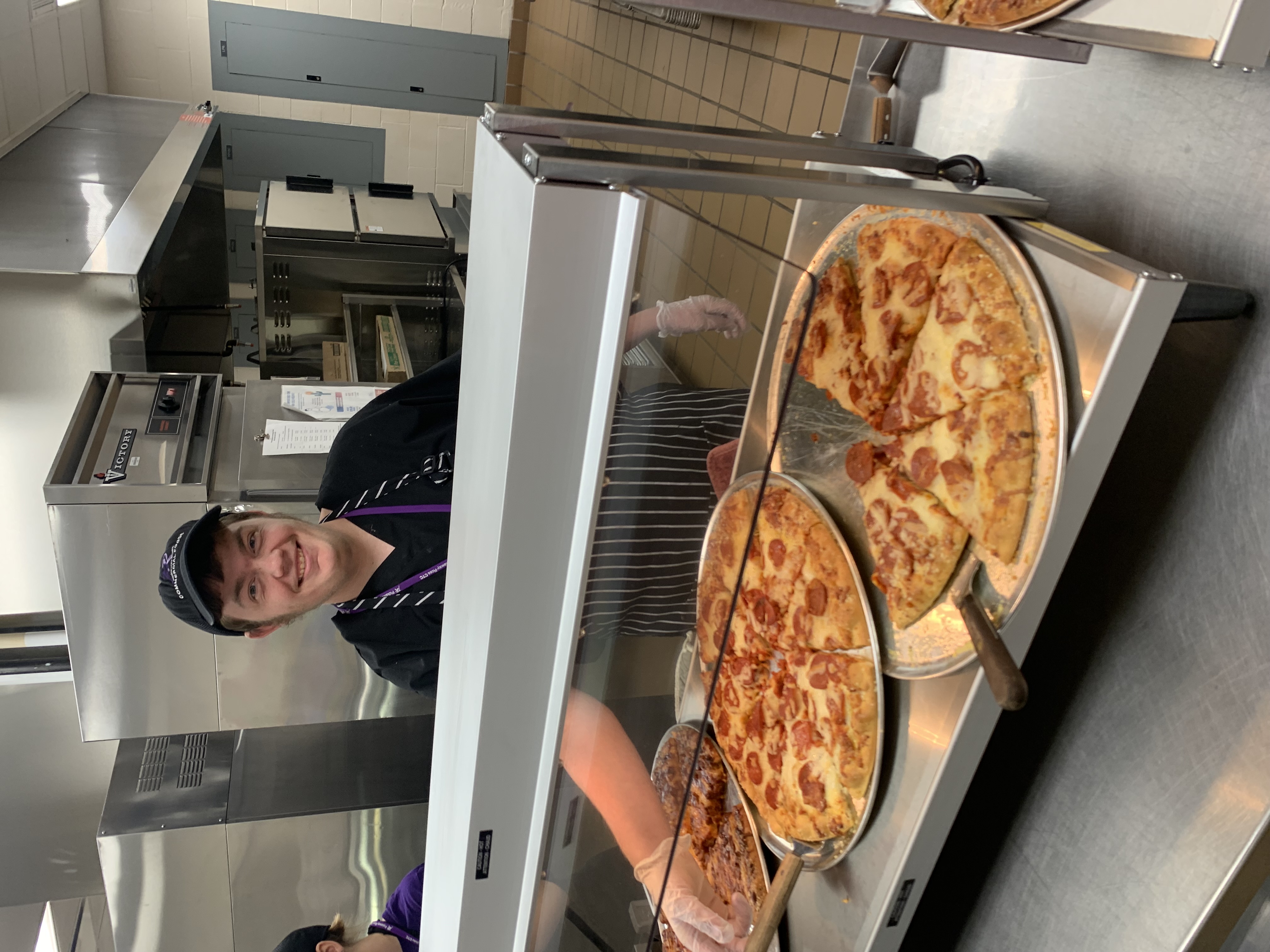 William Fuller works the pizza line at school.