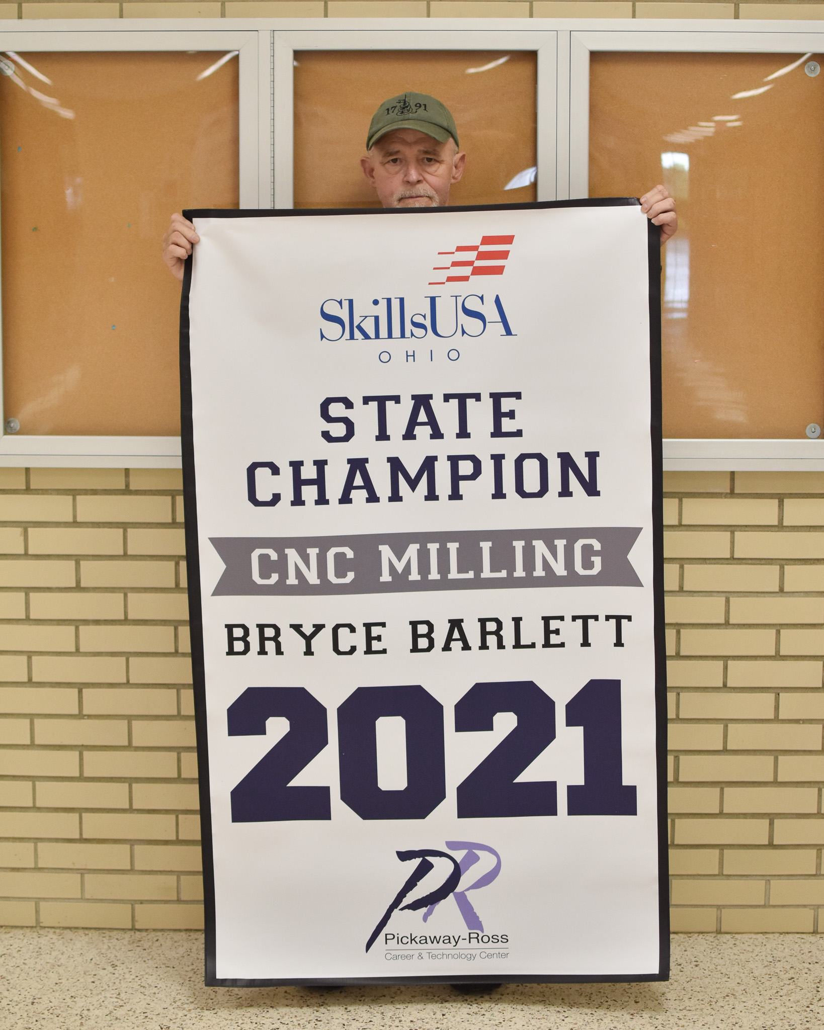 Mr. Ebert behind Skills USA CNC Milling Champion 2021 Banner