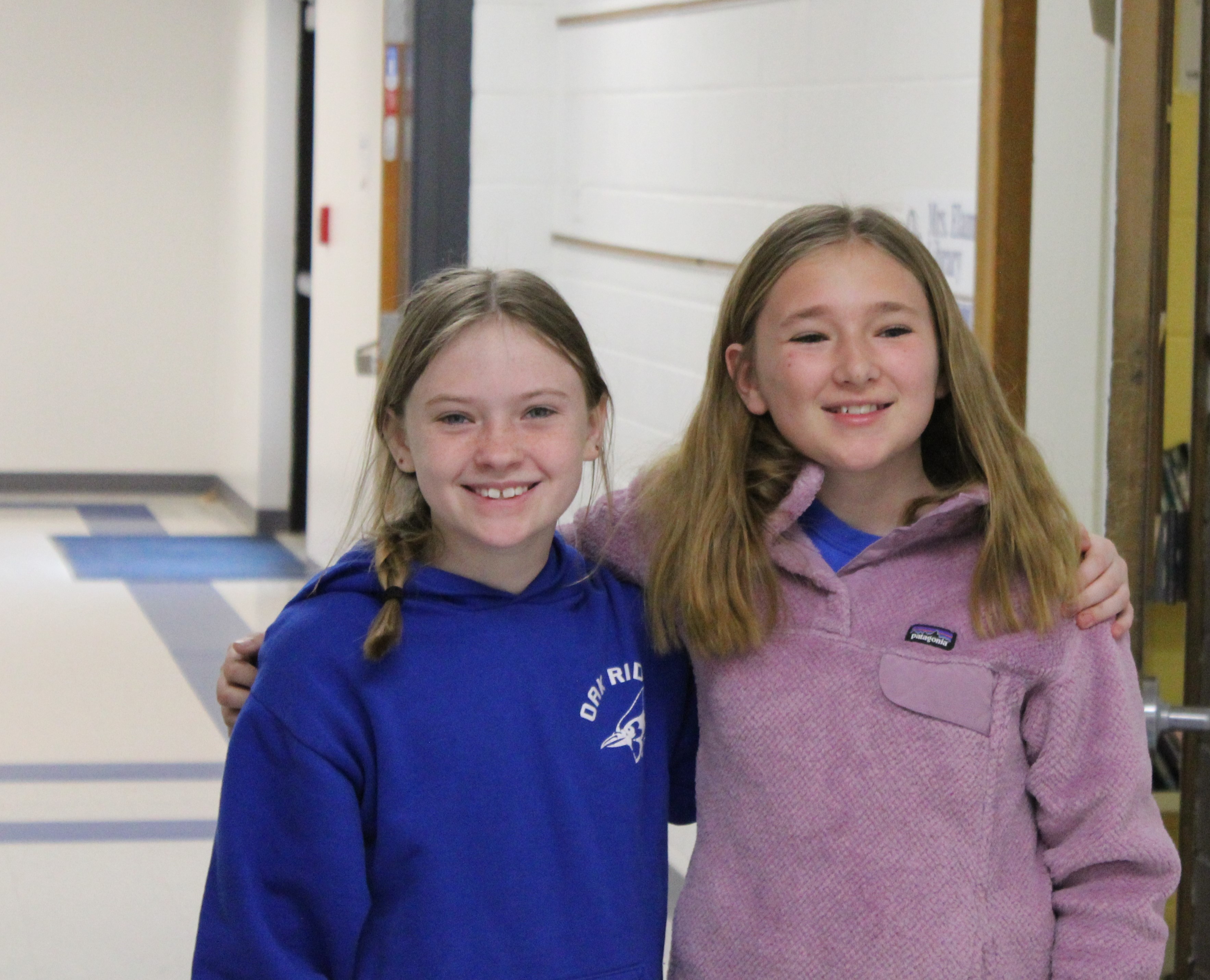Two elementary girls happy in the hall