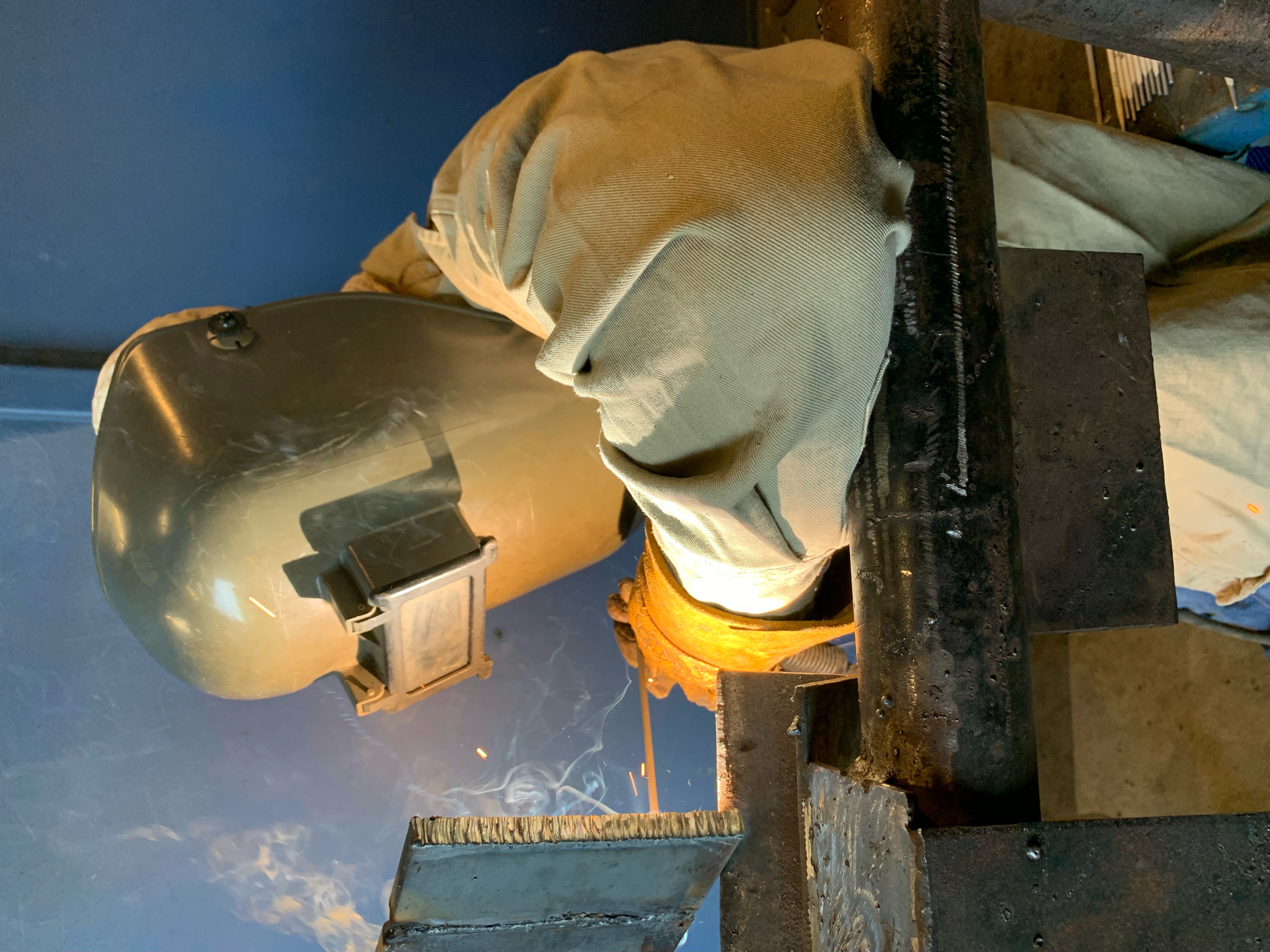 Student welder welding a piece of metal