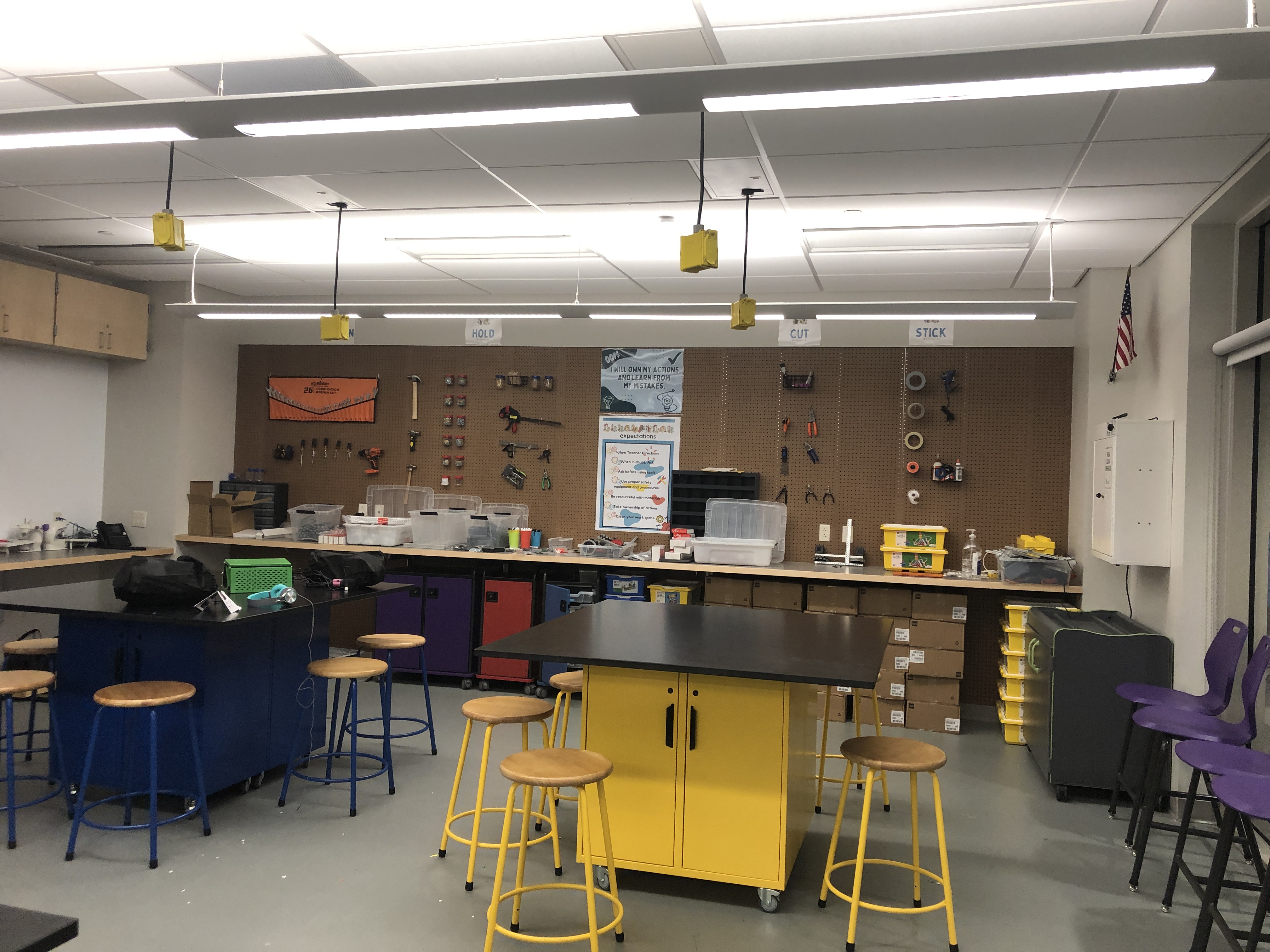 Garage space with peg wall, tools, and yellow work table