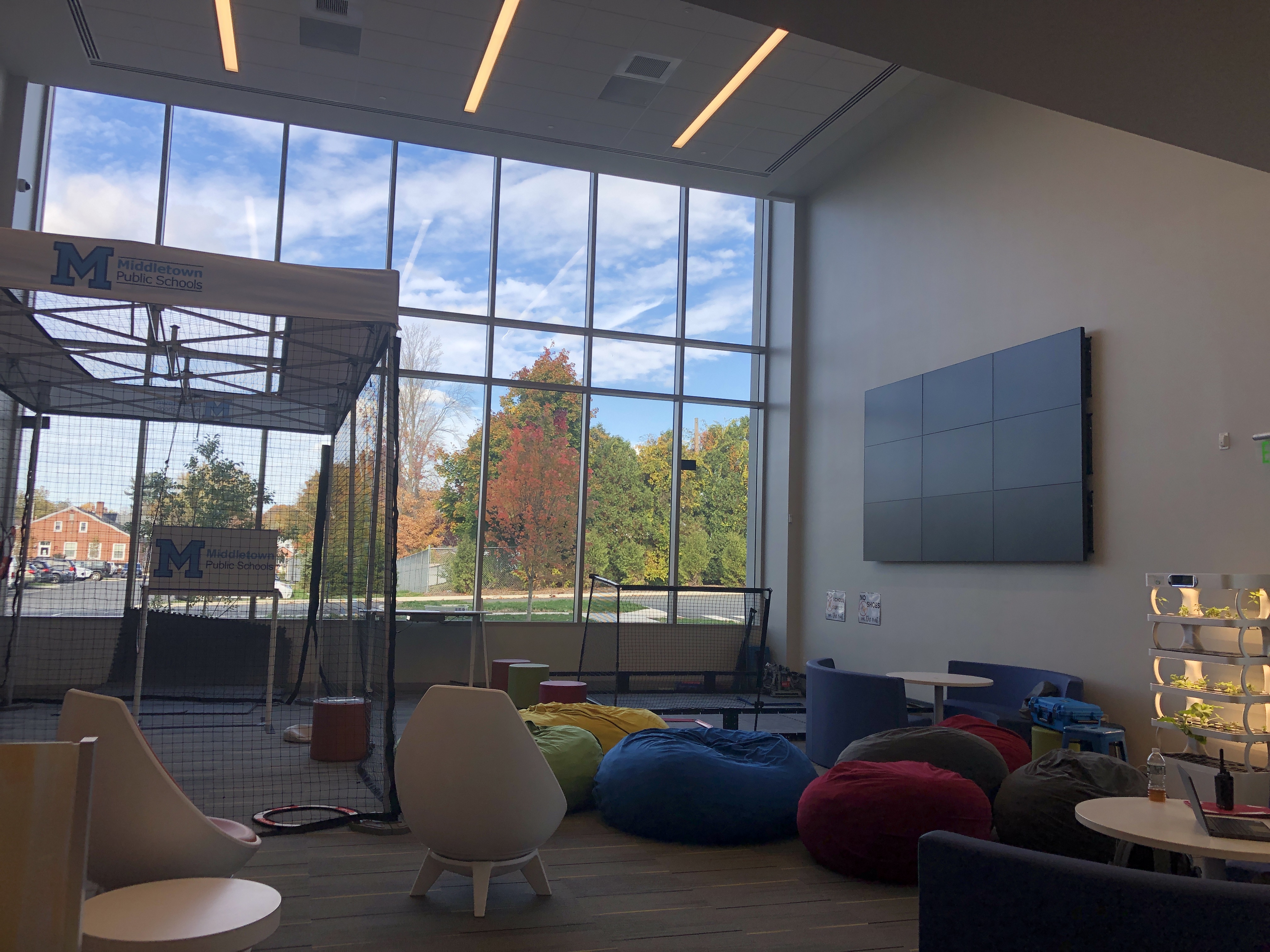 Picture of open space, including drone net, display tv, and flexible seating including beanbags