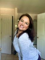 Christine DeSocio, a white woman with long dark hair, smiling into the camera