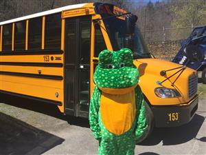 frog mascot beside bus