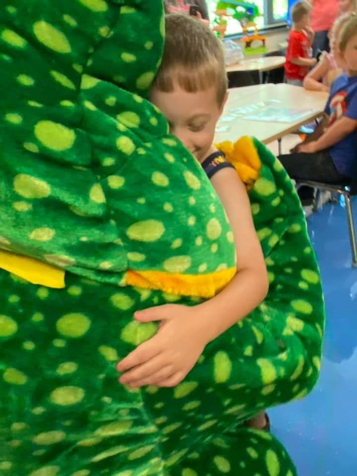 frog mascot hugging kid