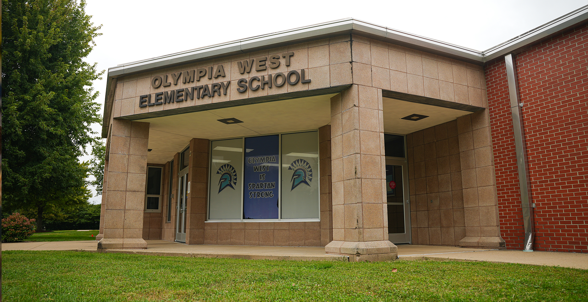 Brick exterior of a school building with light blue and white imagery