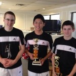 three boys holding a trophy each