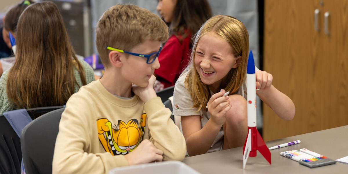 boy and girl playing with a model rocket