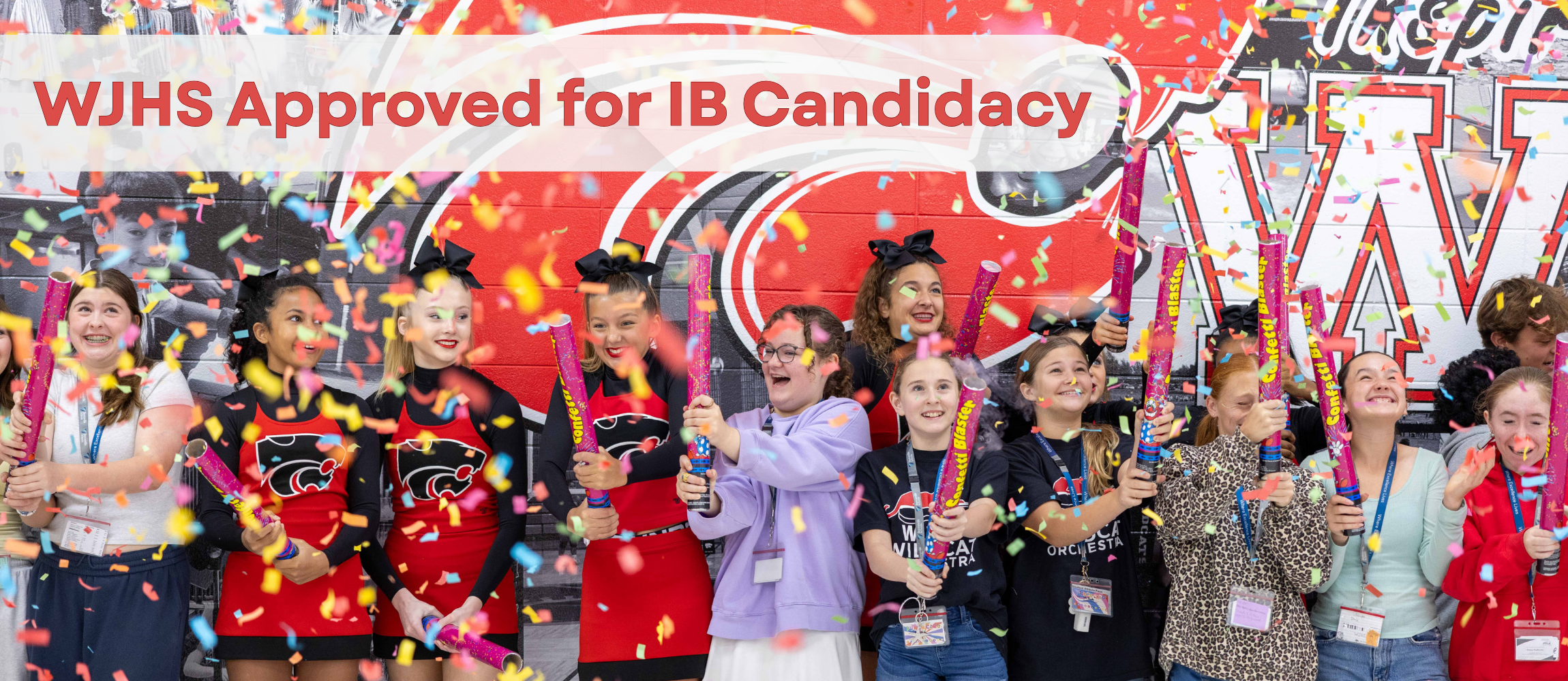 WJHS students lined up in front of a mural with confetti poppers