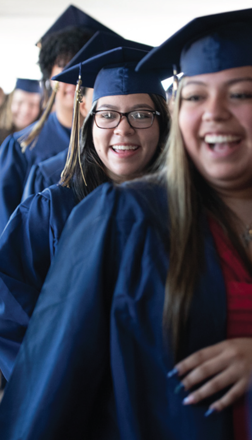 graduates line up in caps and gowns