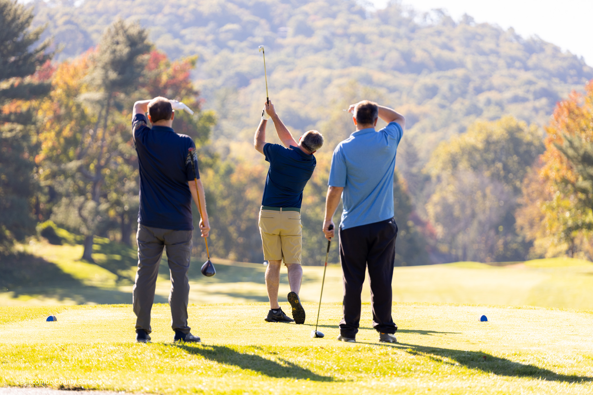 three men playing golf