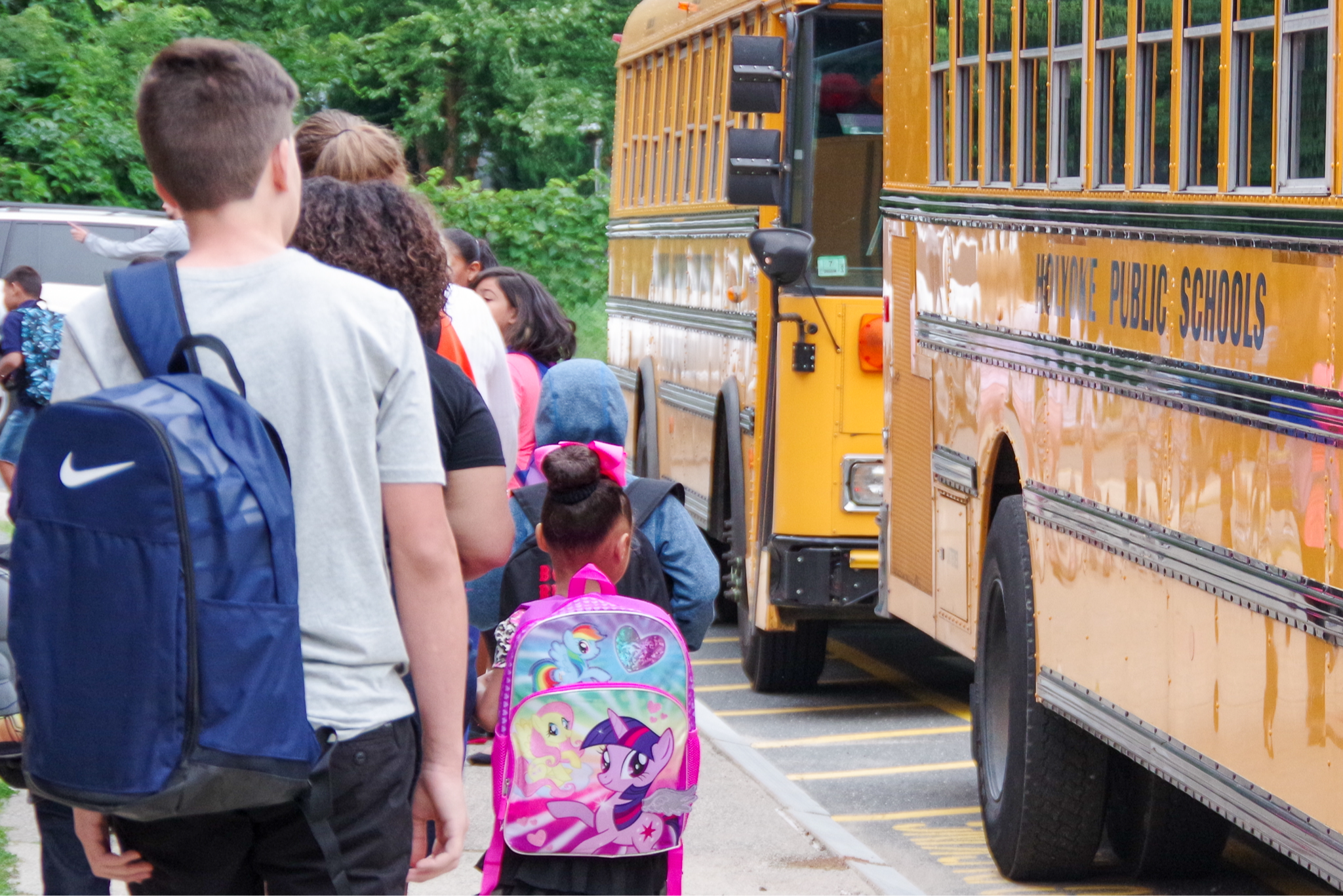 Students walking towards the buses lined outside of school.