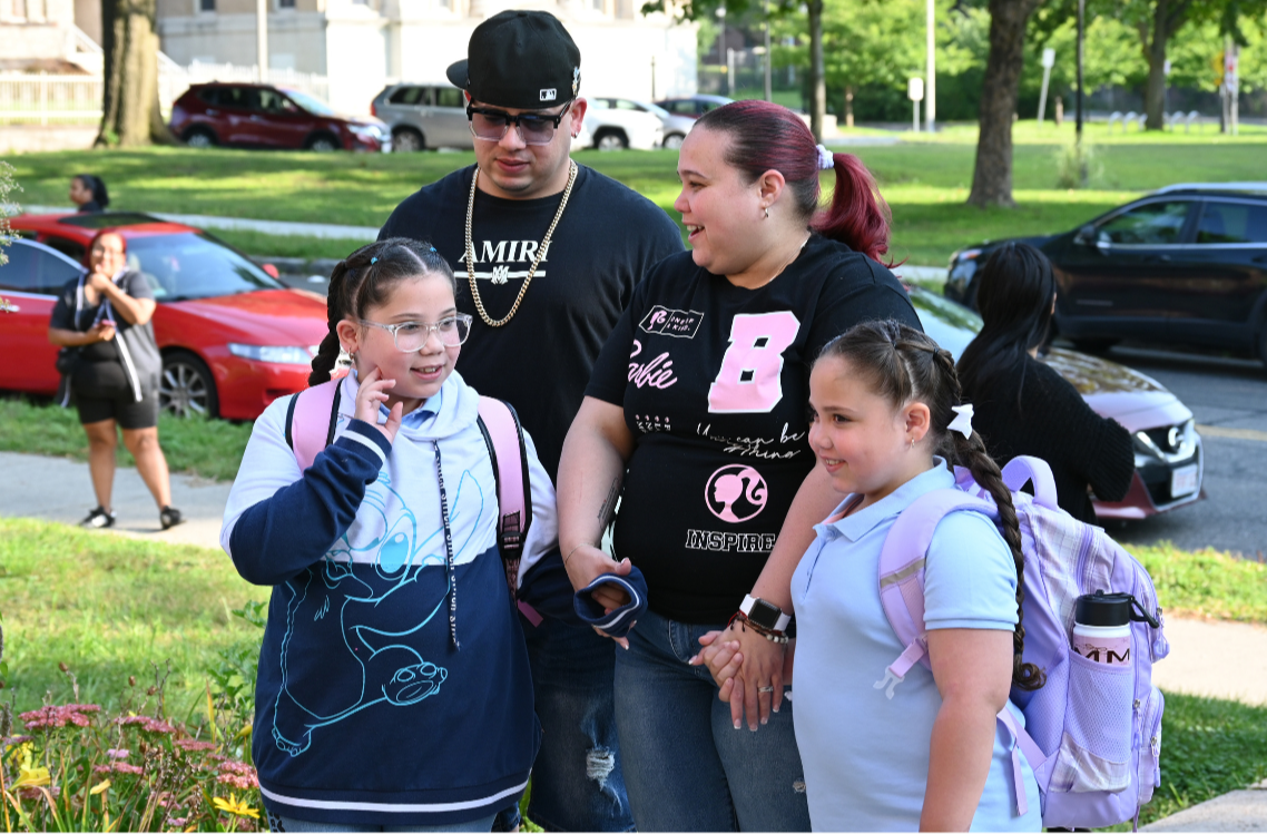 A family accompanies their children to the first day of school at Lawrence