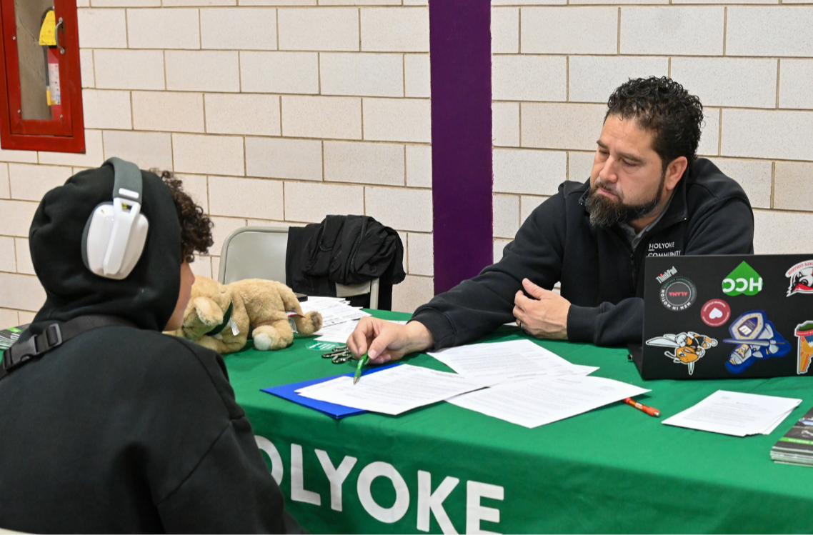 A representative from Holyoke Community College walks a high school senior through the enrollment process